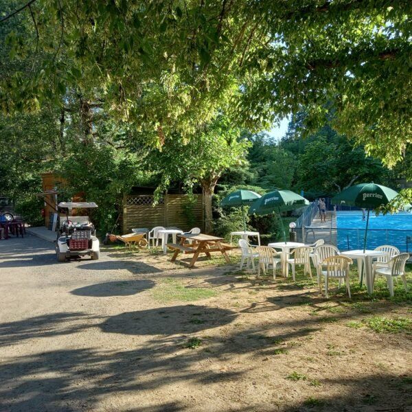 Terraza frente a la piscina del camping Le Valenty en el Lot en Soturac en Occitania
