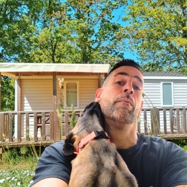 florent, le propriétaire du camping le valenty avec un malinois devant un mobil-home