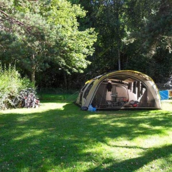 Tente sur un emplacement spacieux et ombragé au Camping du Moulin de Serre à Singles dans le Puy de Dôme proche du parc naturel régional des volcans d'Auvergne