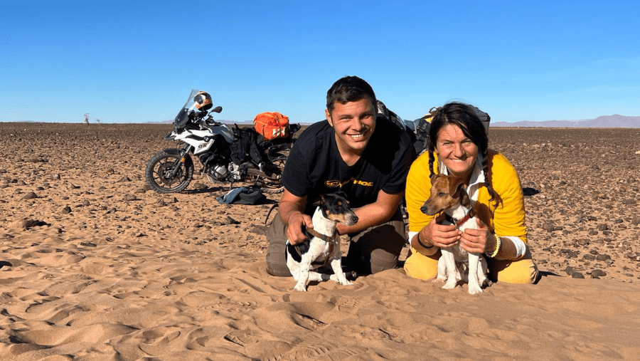 Julien and Coralie with their dogs in the desert in Morocco, during their motorcycle road trip