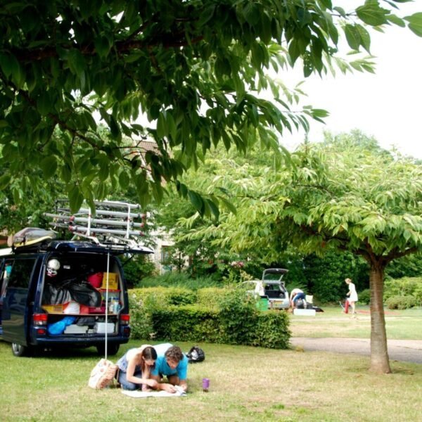 Couple et van sur un emplacement du Camping Municipal Camp'Eure à Pont de l'Arche en Normandie dans l'Eure