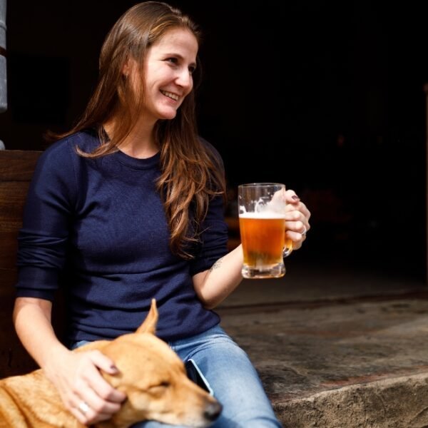 Jeune femme avec son chien buvant une bière au Bar le Calypso à Crozon en Bretagne dans le Finistère