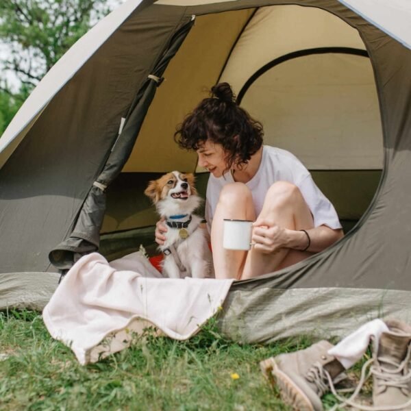 Jeune femme dans sa tente avec son chien au Camping Municipal Camp'Eure à Pont de l'Arche en Normandie dans l'Eure