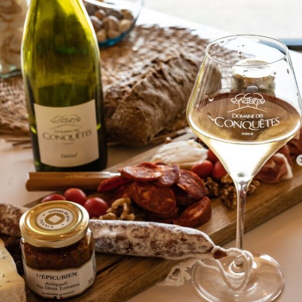 Verre de vin blanc et plateau de charcuterie du vignoble Le Domaine des Conquêtes dans l'Hérault en Occitanie à Aniane