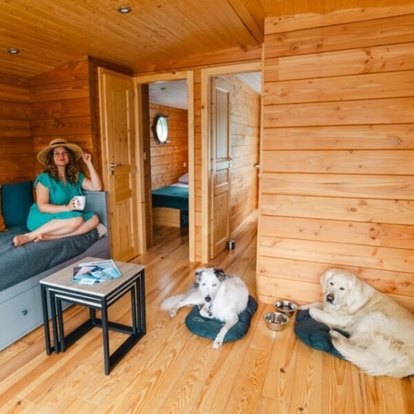 Salon avec deux chiens dans leur panier avec leurs gamelles de l'une des Toues Cabanées du Lac dans les Hautes-Alpes en Provence-Alpes-Côte d'Azur à Le Sauze-du-Lac