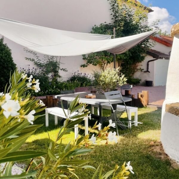 Table de jardin extérieur à l'ombre, entouré de fleurs, à côté du puit AU CLOS DES ORMES en Bourgogne en Saône-et-Loire à Dompierre-les-Ormes