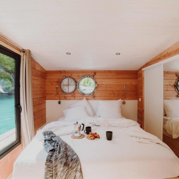 Chambre double avec baie vitrée donnant sur le lac d'une des Toues Cabanées du Lac dans les Hautes-Alpes en Provence-Alpes-Côte d'Azur à Le Sauze-du-Lac