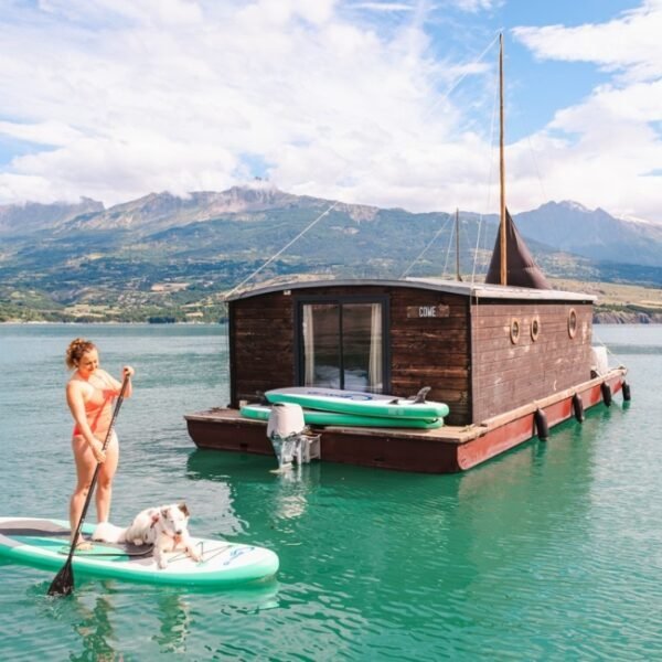 Cani-paddle avec un chien à côté de l'une des Toues Cabanées du Lac dans les Hautes-Alpes en Provence-Alpes-Côte d'Azur à Le Sauze-du-Lac