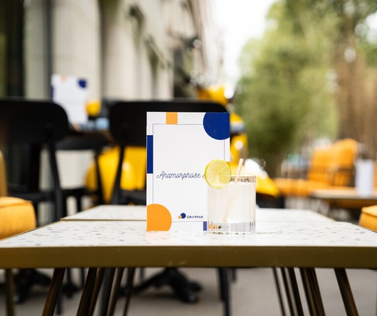 La carte du bar et un cocktail sur un table en terrasse du Bar Anamorphose by Graphik Hôtel à Paris en île-de-France