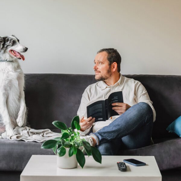 Un chien sur le canapé avec son maitre dans un appartement de l'Appart'City Classic Bordeaux Centre à Bordeaux en Gironde en Nouvelle-Aquitaine