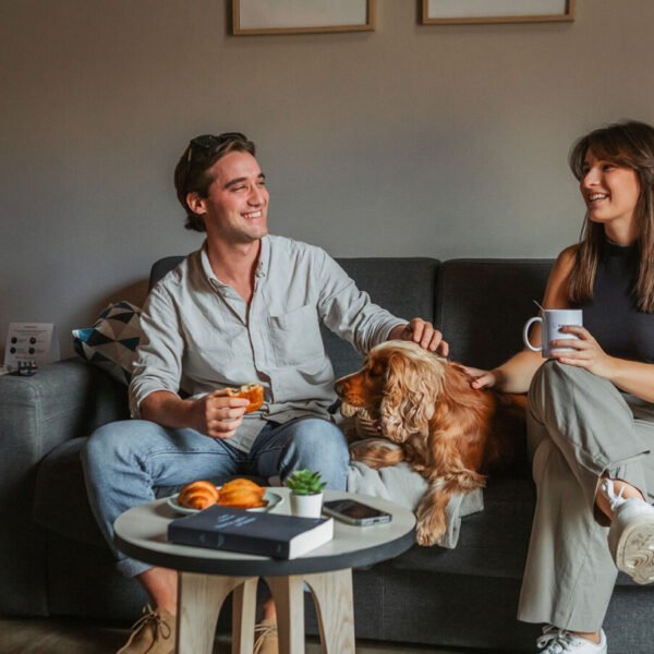 Un couple assis avec un cocker sur le canapé d'un appartement de l'Appart'City Confort Reims Centre *** à Reims en Champagne-Ardenne dans la Marne