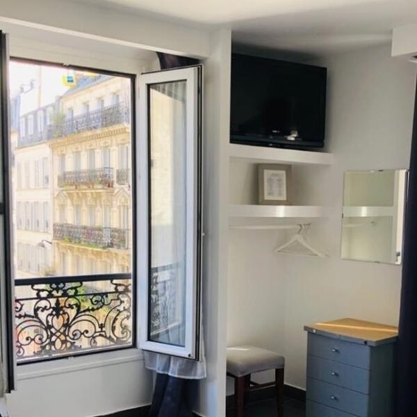 Espace TV et bureau d'une chambre, avec une fenêtre donnant sur la rue à l'Hôtel Clauzel à Paris en Île-de-France