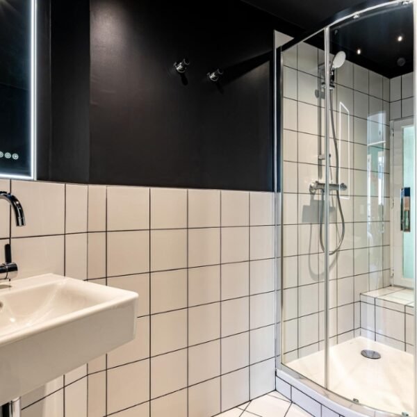 Un salle de bain avec une douche de L'Hôtel Graphik Montparnasse à Paris en Île de France