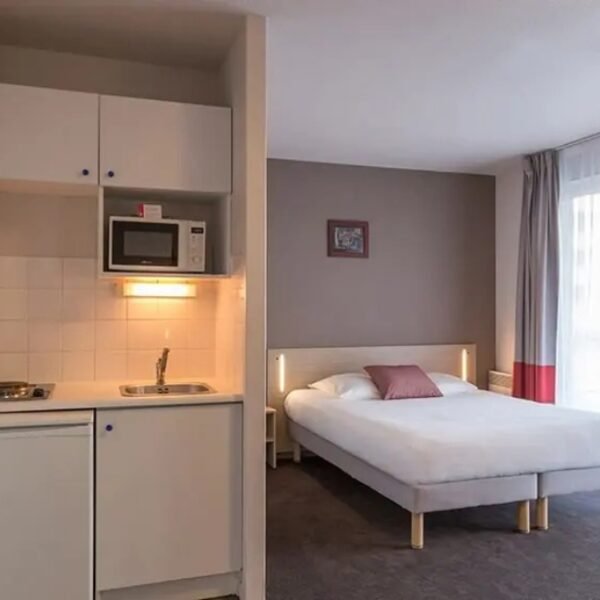 La chambre double et la cuisine d'un appartement de l'Appart'City Classic La Rochelle Centre à La Rochelle en Charente-Maritime en Nouvelle-Aquitaine