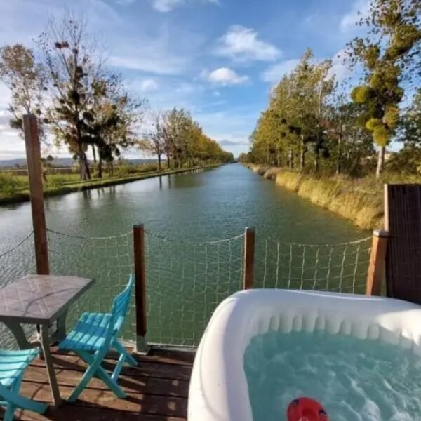 Terrasse donnant sur le canal de Bourgogne, avec jacuzzi privatif et table de jardin du Cottage flottant insolite à Saint-Jean-de-Losne en Côte d'Or en Bourgogne-Franche-Comté