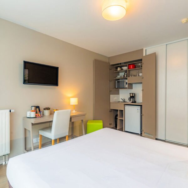 La chambre avec lit double, bureau, télévision et cuisine dissimulée d'un appartement de l'Appart'City Confort Rennes Cesson Sévigné *** à Rennes en Ille-et-Vilaine en Bretagne