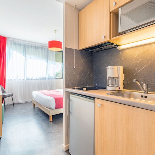 La chambre et la cuisine équipée d'un appartement de l'Appart'City Montpellier Millénaire à Montpellier dans l'Hérault en Occitanie