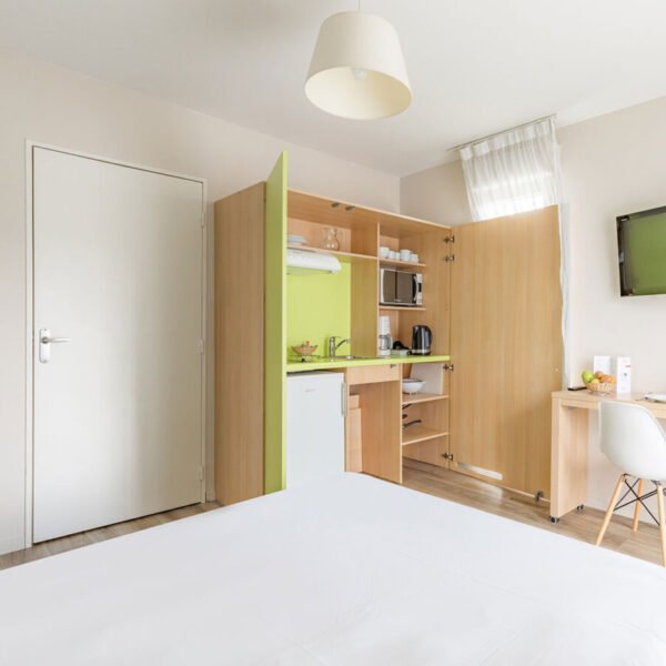 La chambre avec un lit double, cuisine équipée et bureau d'un appartement de l'Appart'City Confort Tours *** à Tours en Indre-et-Loire dans le Centre-Val-de-Loire