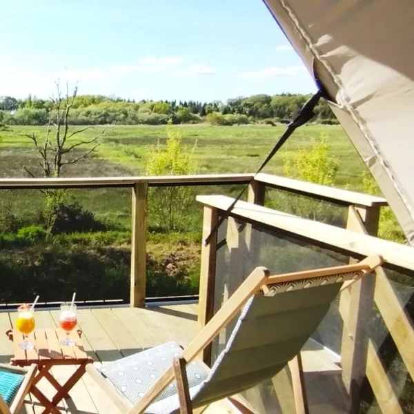 La terrasse de la tente là-haut, hébergement insolite, avec chaises longues et cocktails du Camping Les Embruns à Camoëlin dans le Morbihan en Bretagne