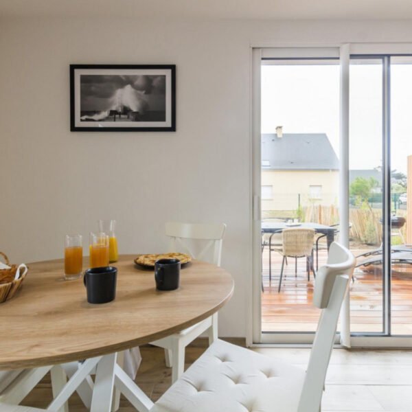 La table de la salle à manger donnant sur la terrasse du Gîte Face au vent à Port-Bail-sur-Mer dans la Manche en Normandie