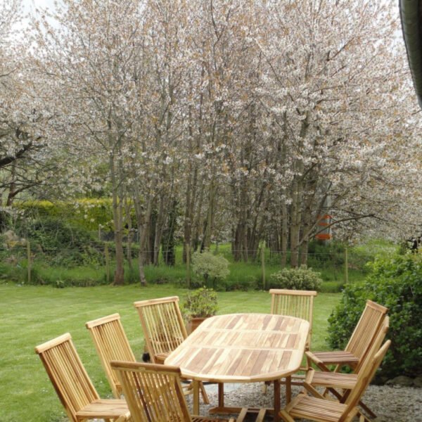 La table de jardin avec les arbres fleuris en fond du Gîte La Couplière à Vicq-sur-mer dans la Manche en Normandie