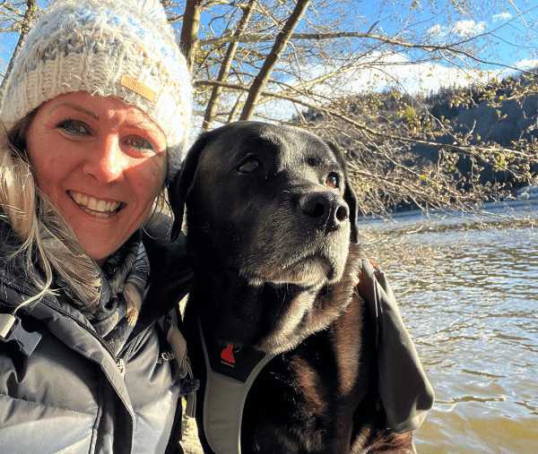 une femme et son chien devant l'étang pour tester le nouveau matériel pour chien de chez Decathlon