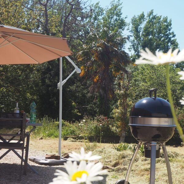 La terrasse avec le salon de jardin et le barbecue au Gîte Le Bois aux Écureuils à Fierville-les-mines dans la Manche en Normandie