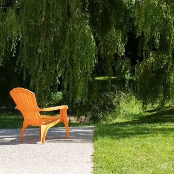 Une chaise de jardin dans le jardin ouvert du Gîte Le Domaine de la Vallée à Saint-Martin-de-Varreville dans la Manche en Normandie