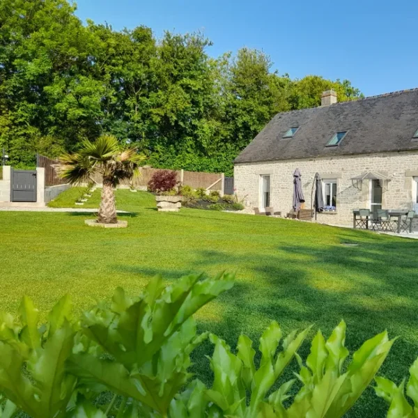 Le grand jardin et la façade du Gîte La Bignone à Saint-Marcouf dans la Manche en Normandie