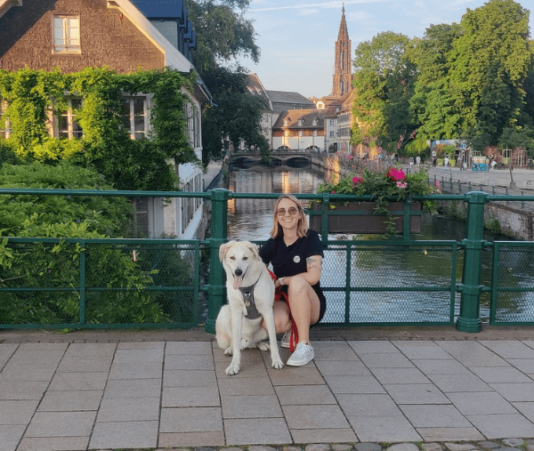 un chien et sa propriétaire sont devant un canal à Strasbourg, incontournable à découvrir