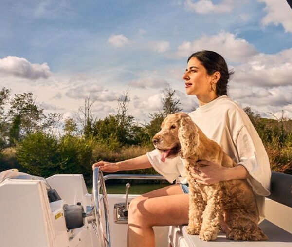 femme avec un chien sur un bateau sans permis