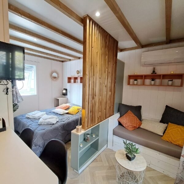 Chambre avec double lit et petit sofa au Camping L’Oasis du Verdon à Aups dans le Var en Provence-Alpes-Côte d'Azur