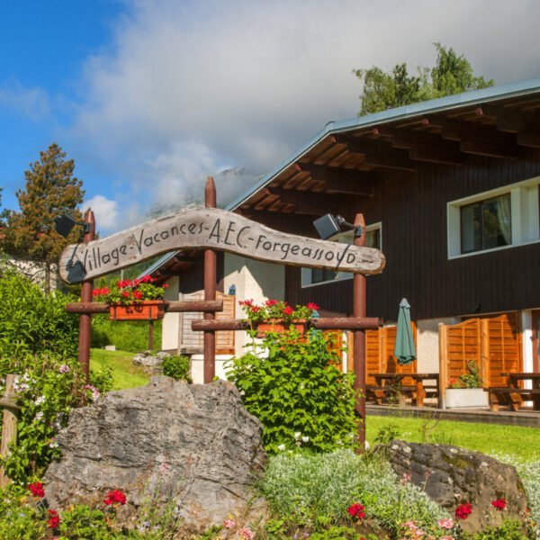 Façade du AEC village Vacances Forgeassoud avec de jolis géranium en premier plan