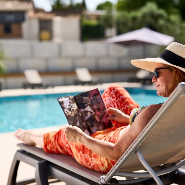 Farniente et lecture au bord de la piscine du Camping La Cerise en Provence au pied du Mont Ventoux près de Carpentras aux portes du Lubéron dans le Sud de la France