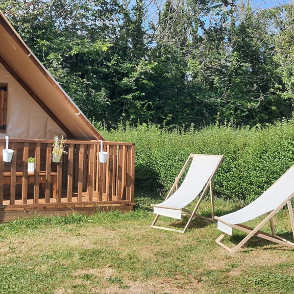 Chaises longues devant une tente au Camping Sous les Pommiers en Normandie dans le Calvados