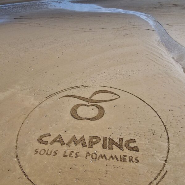 Logo sur la plage du Camping Sous les Pommiers en Normandie dans le Calvados
