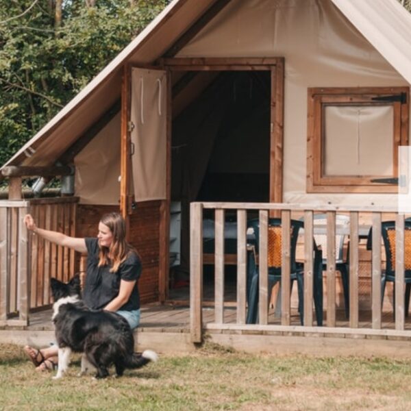 Chien et son maitre devant une tente du Camping Sous les Pommiers à Trévières dans le Calvados
