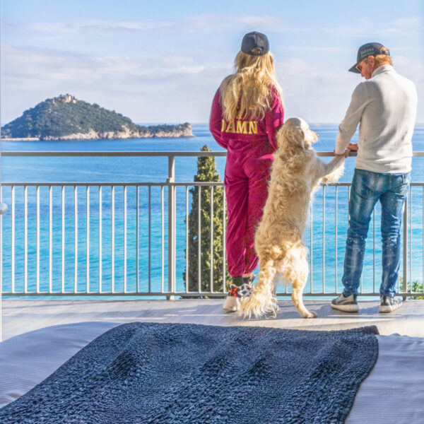 Un couple et son chien qui regarde la mer Méditerranée depuis la terrasse de Baba Residences à Alassio en Italie