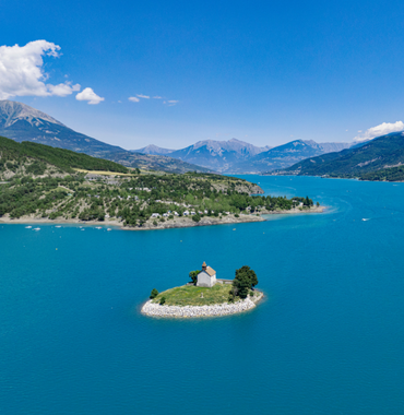île au milieu du lac de Serre Ponçon avec une chapelle