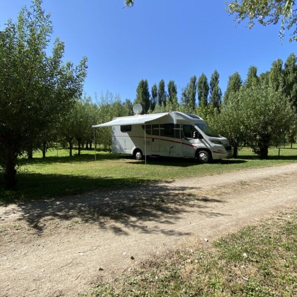 Motorhome on a shaded pitch at Camping Le Marais Sauvage in Vendée in the heart of the Poitevin marshes near Niort in Pays de Loire
