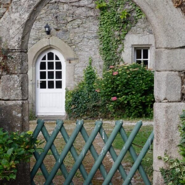 Stenen deur die uitkomt op de tuin van de Gites du Manoir de Kerhir in Bretagne in Trédarzec in de Côtes d'Armor