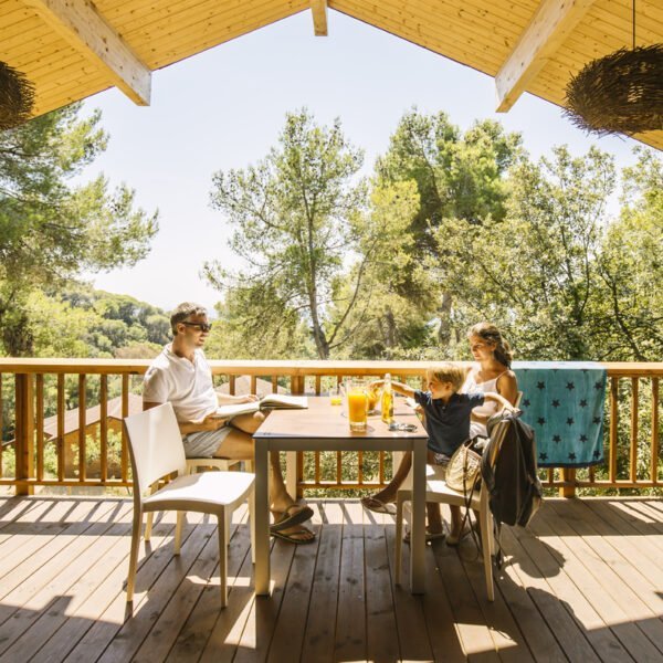 Famille sur une terrasse d'un mobilhome du Camping Sea Green Cala Llevado en Espagne sur la Costa Brava à Tossa de Mar