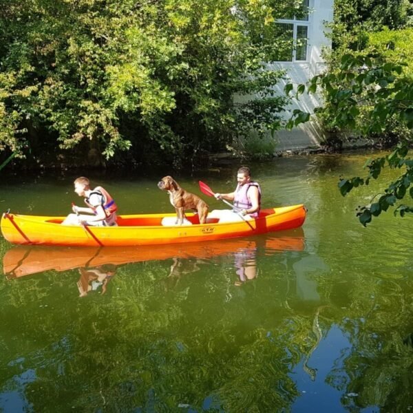 Vacanciers et leur chien sur l'un des canoés de la base Parcoul Canoe en Dordogne dans le Périgord en Nouvelle Aquitaine