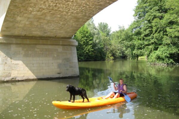 Vacancier et son chien sur l'un des canoés de la base Parcoul Canoe en Dordogne dans le Périgord en Nouvelle Aquitaine