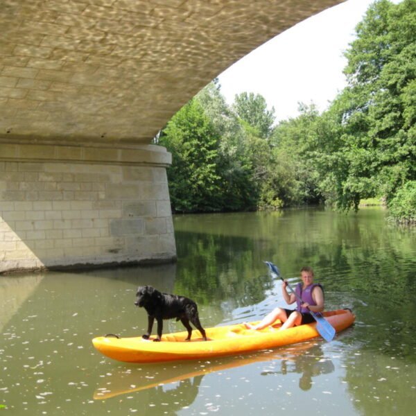 Vacancier et son chien sur l'un des canoés de la base Parcoul Canoe en Dordogne dans le Périgord en Nouvelle Aquitaine