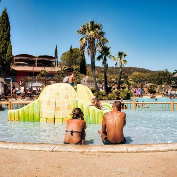 Parents devant la piscine pour enfant du Domaine de la Bergerie dans le Var