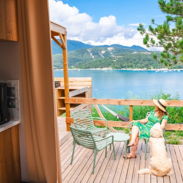 Hébergement avec vue sur le lac et les montagnes, sur la terrasse avec son chien au camping Sunelia La Presqu'île **** dans les Hautes-Alpes en Provence-Alpes-Côte d'Azur à Prunières