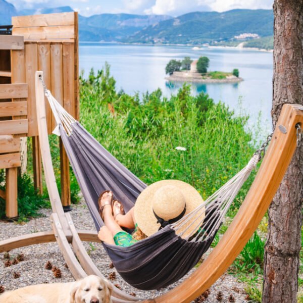 Hamac de la terrasse d'un hébergement avec vue sur le lac et les montagnes au camping Sunelia La Presqu'île **** dans les Hautes-Alpes en Provence-Alpes-Côte d'Azur à Prunières