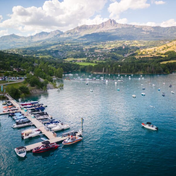 Le lac Serre-Ponçon et pontons avec des bateaux à deux pas du camping Sunelia La Presqu'île **** dans les Hautes-Alpes en Provence-Alpes-Côte d'Azur à Prunières