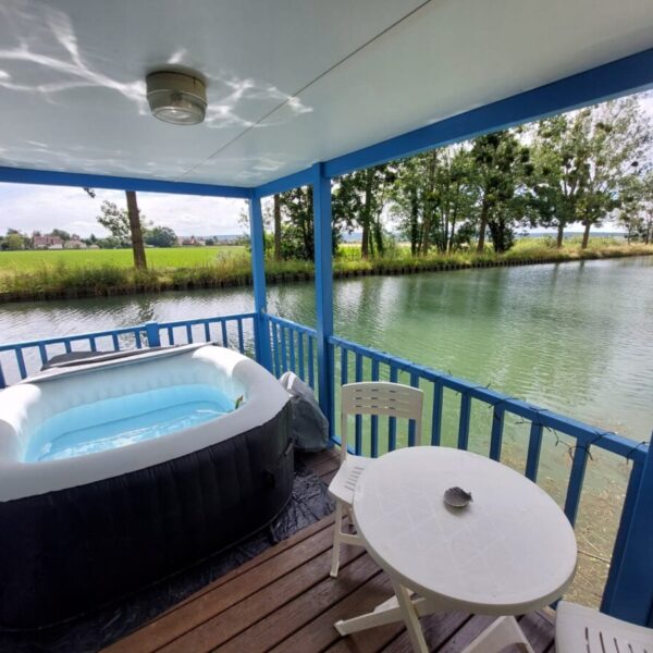 Terrasse donnant sur le canal de Bourgogne, avec jacuzzi privatif et table de jardin du Cottage flottant insolite à Saint-Jean-de-Losne en Côte d'Or en Bourgogne-Franche-Comté